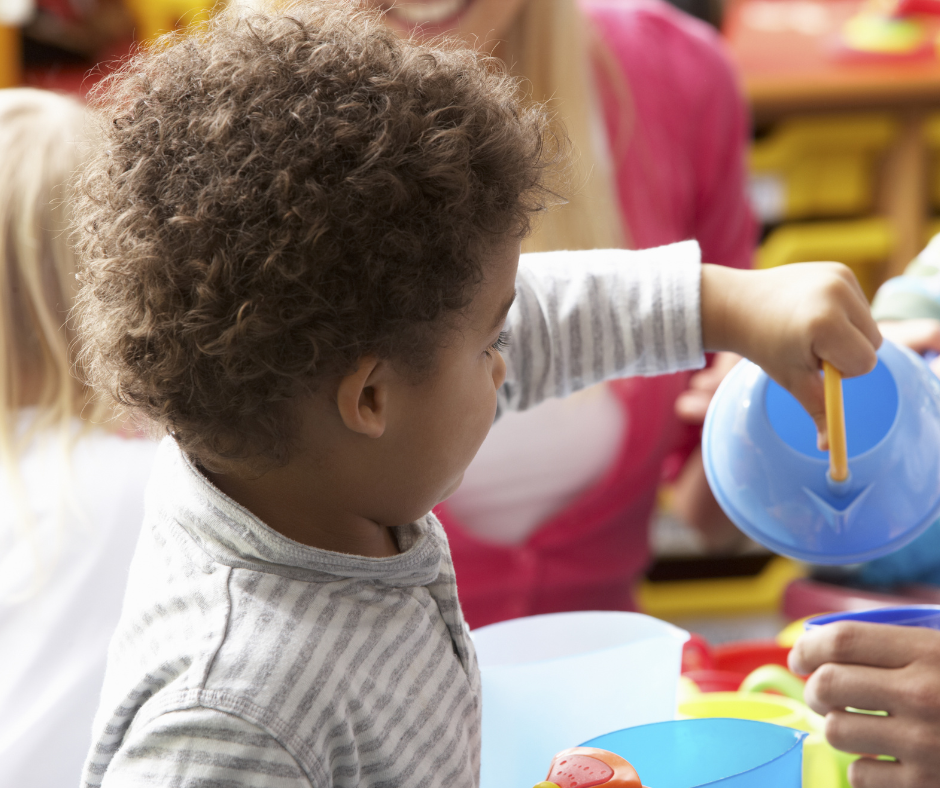 pouring tea - child in nursery pretending to pour tea from a teapot