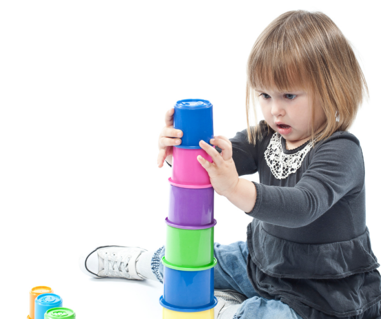 Child concentrating on stacking blocks developing a schema in learning