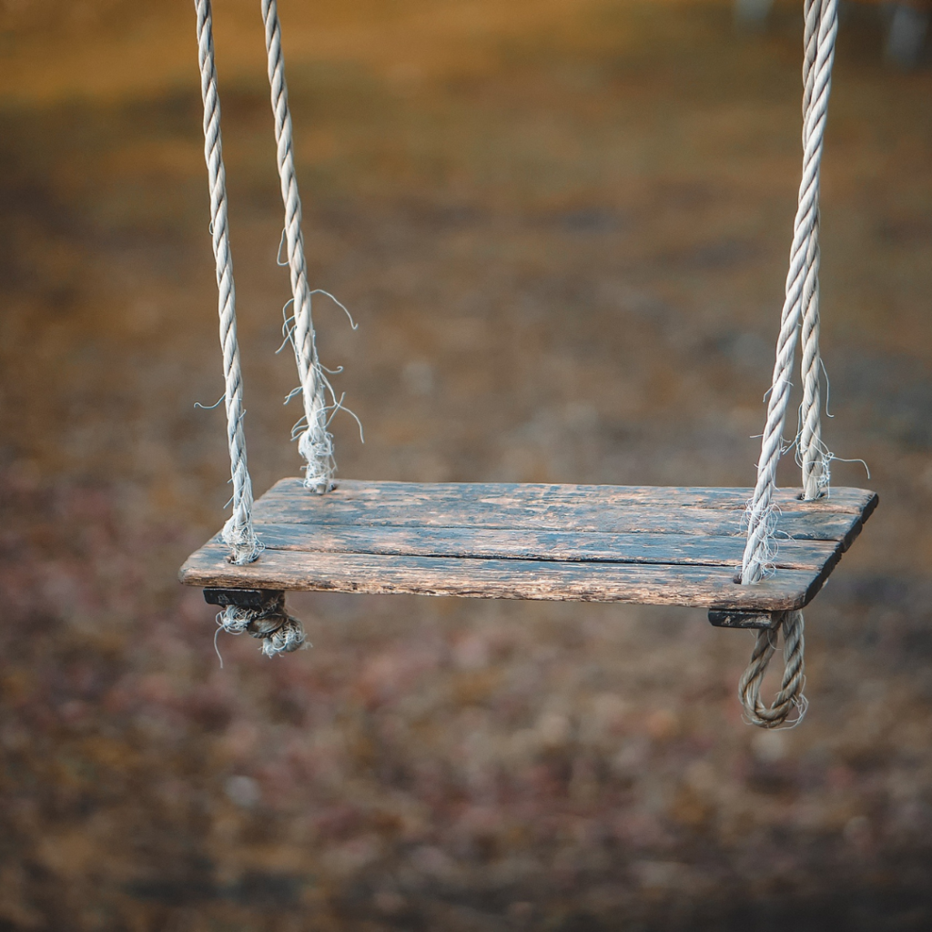 An image of a swing with ropes and a wooden seat