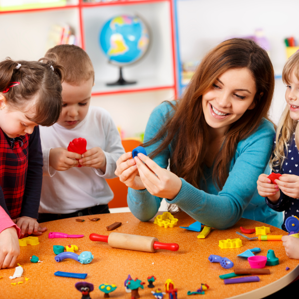 practitioner modelling an activity to nursery children