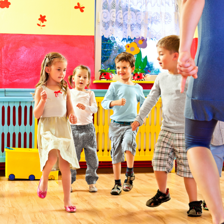 a teacher and nursery children jumping together