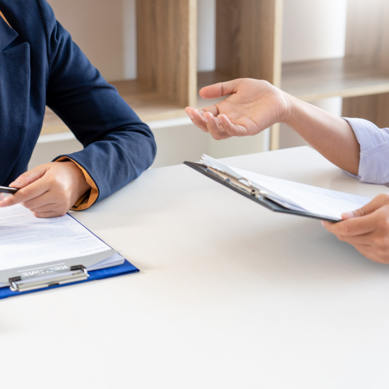 An image of 2 people sat at a table making a judgement about something.