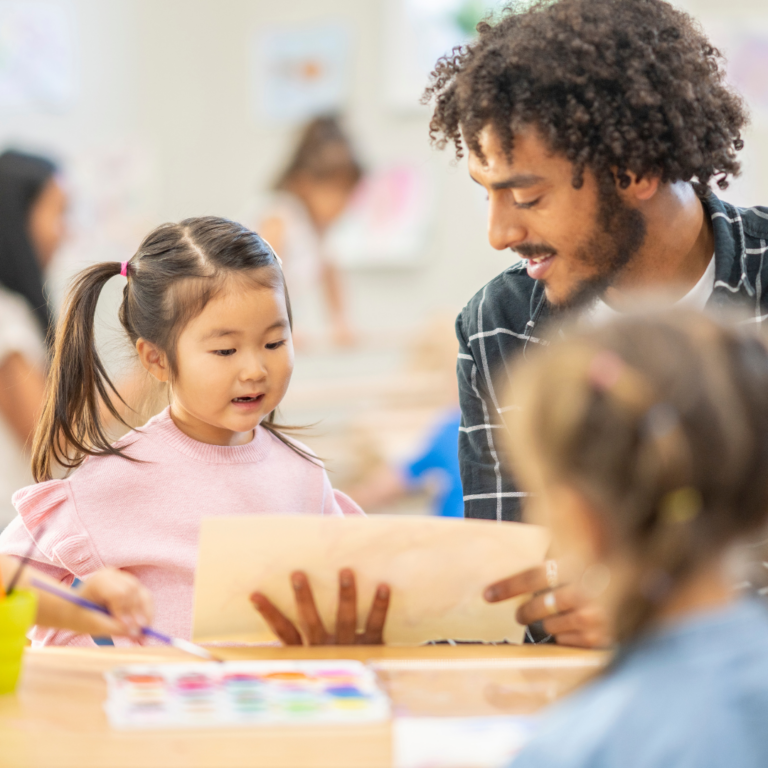 An image of an apprentice nursery practitioner with children engaged in a learning activity