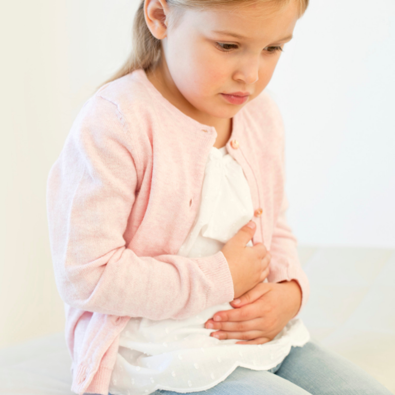 an image of a preschooler with tummy pain holding their tummy