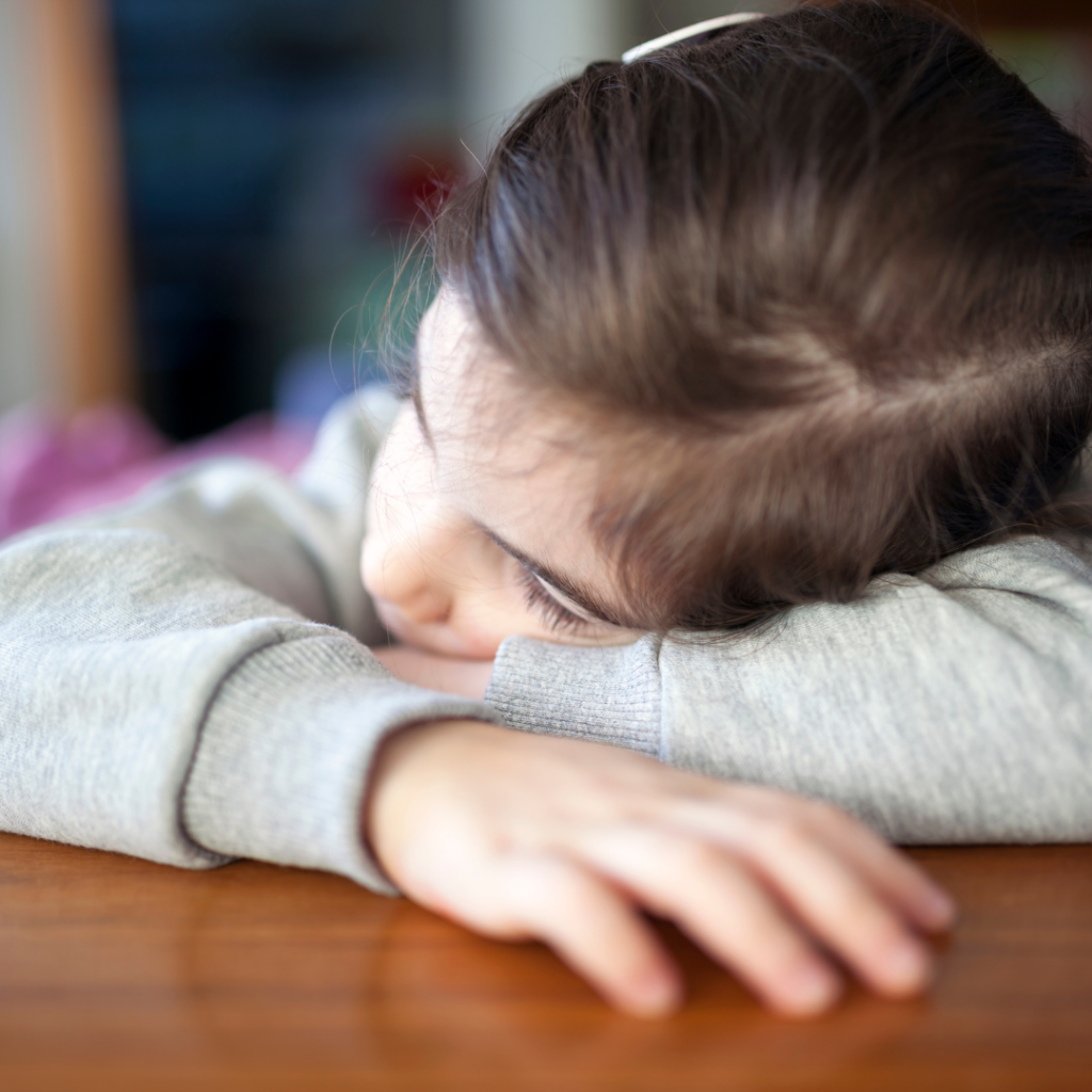 an image of an upset child with their head on their arms