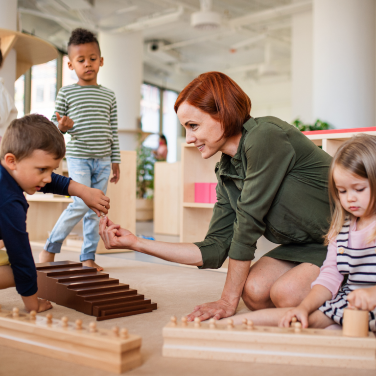 Early Years teacher supporting children during a table top activity