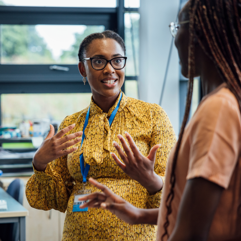 An image of a nursery SENDco talking to a team member and smiling.