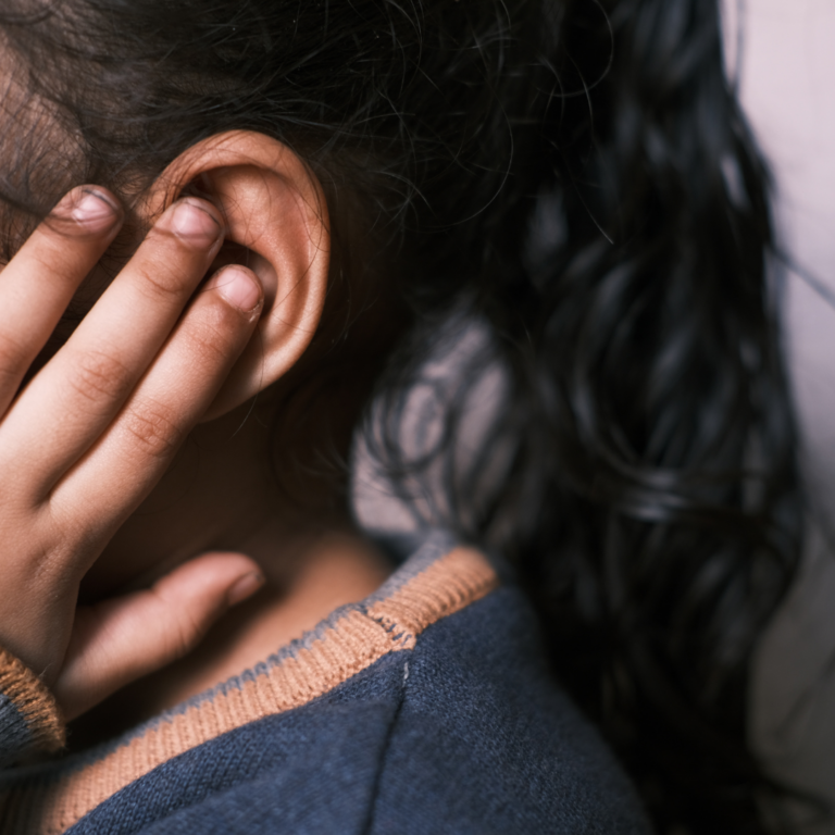 A child covering their ears to block out the noise